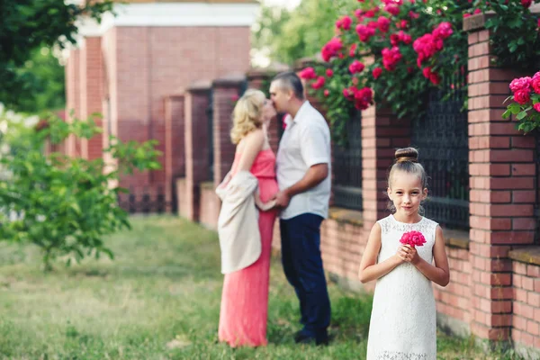 バラの花とフェンスの近くの自然の中の家族 — ストック写真