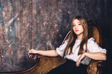 sevimli genç kız retro bir sandalyede oturuyor poz