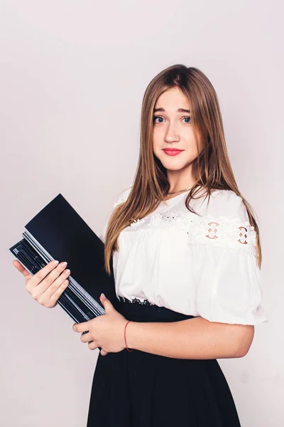 Nice young girl with a pile of magazines in her hands. — Stock Photo, Image