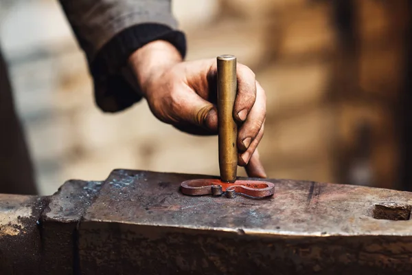 Close-up blacksmith stigmatizes his product. — Stock Photo, Image