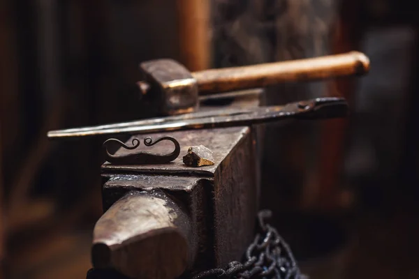 Närbild av en smed städet med en hammare, tång, firesteel och flint. — Stockfoto