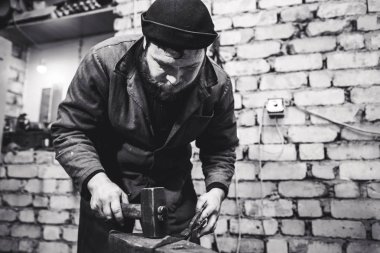 El ile örs üzerinde kırmızı-sıcak metal dövme demirci.