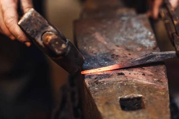 Blacksmith makes an artistic forging of hot metal on the anvil. — Stock Photo, Image