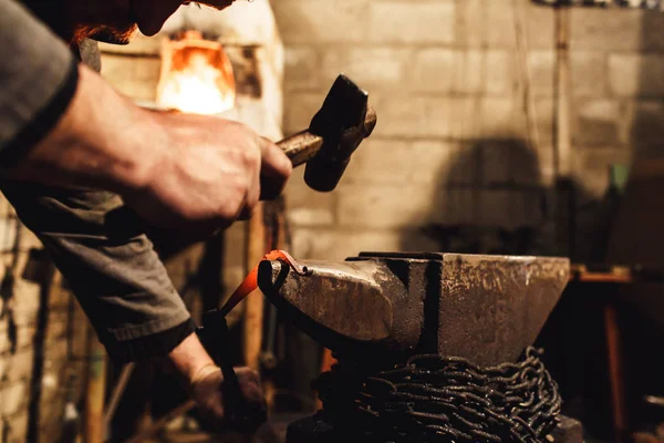 Blacksmith makes an artistic forging of hot metal on the anvil. — Stock Photo, Image