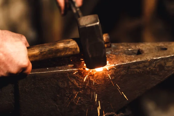 Kovář ruční kování rozžhavený kov na kovadlinu v kovárně s jiskrou ohňostroj. — Stock fotografie