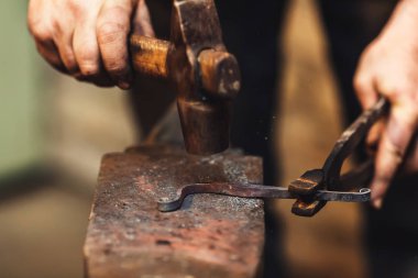 Demirci sıcak metal bir sanatsal dövme örs üzerinde yapar.
