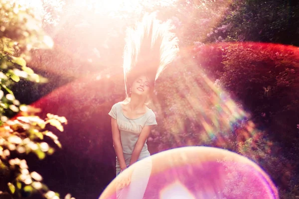 Prachtige lente. Een mooi jong meisje geniet van natuur en zonlicht onder de bloeiende lila. — Stockfoto