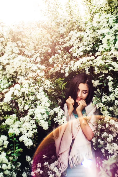 Nádherné jarní. Krásná mladá dívka má příroda a slunečním světlem mezi kvetoucí tavolník. — Stock fotografie