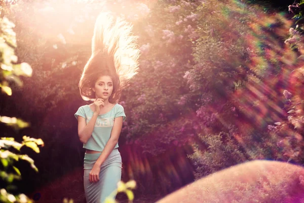 Maravillosa primavera. Una hermosa joven disfruta de la naturaleza y la luz del sol entre la floreciente lila . —  Fotos de Stock