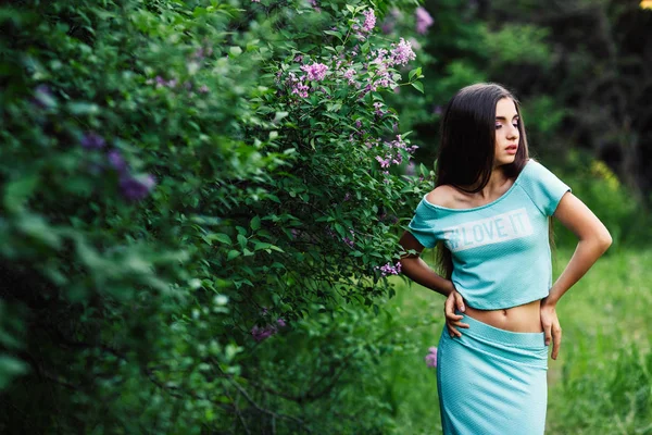 Maravillosa primavera. Linda joven posando en la naturaleza cerca de la floración lila . —  Fotos de Stock