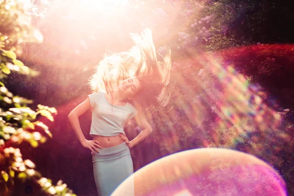 Nádherné jarní. Krásná mladá dívka má příroda a slunečním světlem mezi kvetoucí šeřík. — Stock fotografie