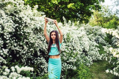 Bahar çiçek açan doğanın keyfini genç kız. Kız kendini çiçek yaprakları ile sprinkles.