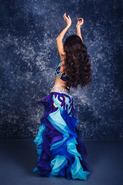 Jovem menina atraente em um terno azul dança da barriga dança . — Fotografia de Stock