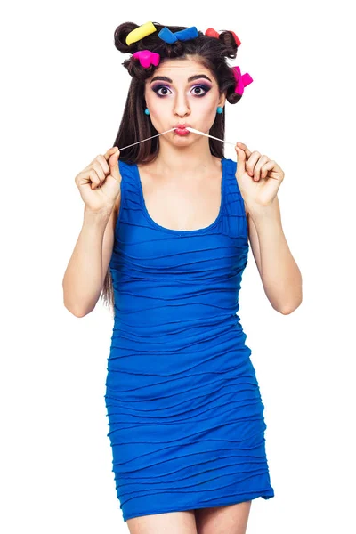 Menina bonita em um vestido azul com encrespadores puxa chiclete . — Fotografia de Stock