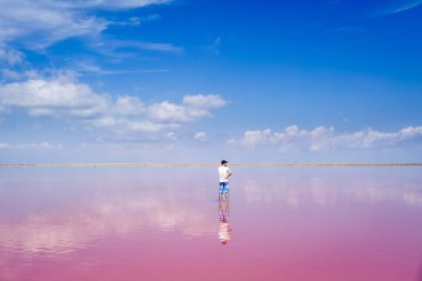 adam tuzlu pembe gölün ortasında duruyor.