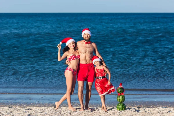 Young friendly family fun celebrating summer Christmas on beach. — Stock Photo, Image