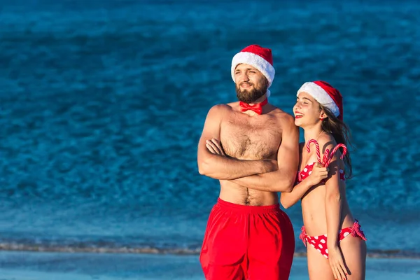 Wesoły mężczyzna i dziewczynka w kapelusze Santa trzyma Christmas lizaki. — Zdjęcie stockowe