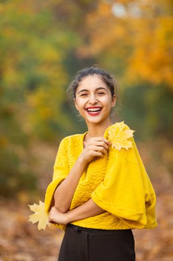 Sonbahar akçaağaç yapraklı neşeli kadın portresi parkta.