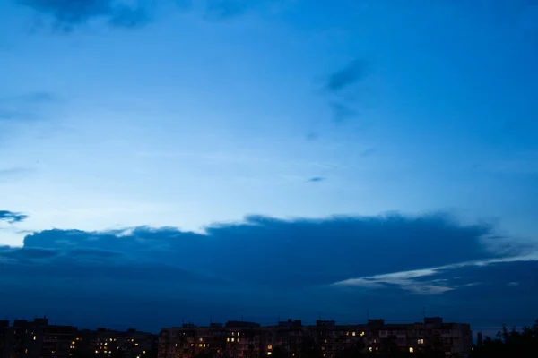 在深蓝色的天空中 只能看到房屋的轮廓 夕阳西下的天空笼罩着房子的屋顶 郊区的小房子在水平线上 — 图库照片