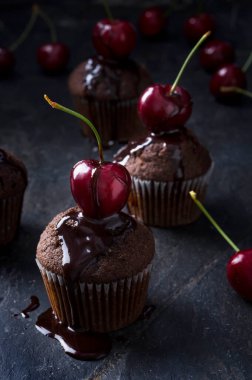 Taze kirazlı çikolatalı kek ve taş yüzeyinde çikolata sosu.