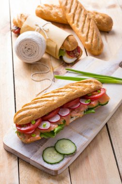 Tahta arka planda çeşitli dolguları olan taze denizaltı sandviçleri.