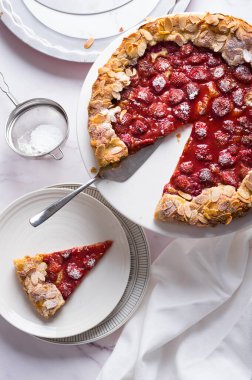 Beyaz mermer zemin üzerinde lezzetli pişmiş rustik çilekli turta, üst manzara.