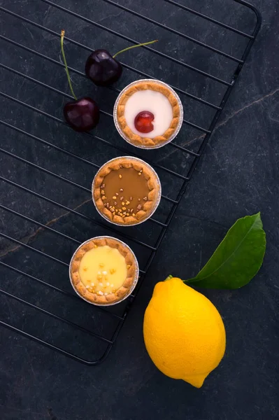 Разнообразие Вишневых Лимонных Карамельных Тарталетки Минималистичный Вид Сверху Темно Каменном — стоковое фото