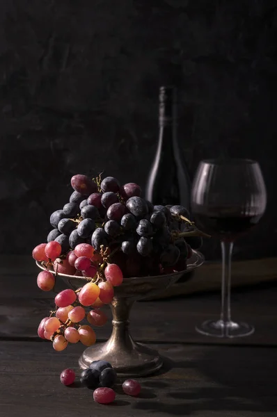 Vista Frontal Tazón Fruta Alta Uva Roja Negra Con Botella —  Fotos de Stock