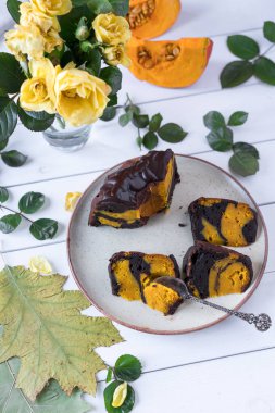 rustik kahverengi renk tabakta kabak ve çikolatalı kek dekorasyon olarak yapraklar