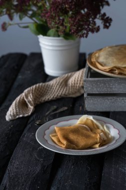 Ev yapımı krep, karanlık bir ahşap zemin üzerinde rustik tarzı bir kahvaltı