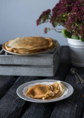 Ev yapımı krep, karanlık bir ahşap zemin üzerinde rustik tarzı bir kahvaltı