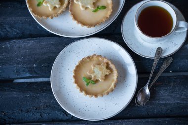 rustik plaka, dekorasyon, çay olarak nane yaprağı üzerinde mini tartı bir tatlı