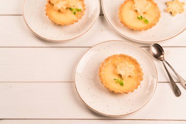 bir ev yapımı limon tartı, ahşap zemin üzerinde rustik plaka üzerinde kar tanesi Çerezler ile dekore edilmiş limon lezzet