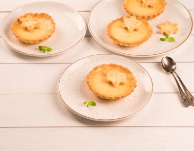 bir ev yapımı limon tartı, ahşap zemin üzerinde rustik plaka üzerinde kar tanesi Çerezler ile dekore edilmiş limon lezzet