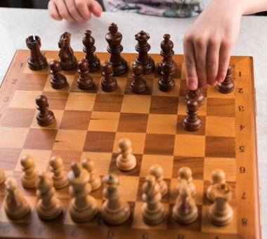 oyun satranç, kahverengi renk satranç tahtası, rehin tutan çocuğun el, 