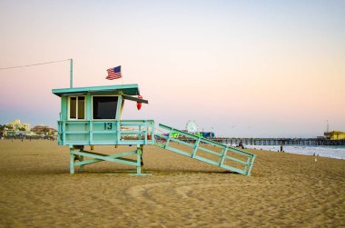 Gün batımında Santa Monica sahilinde bir cankurtaran istasyonu