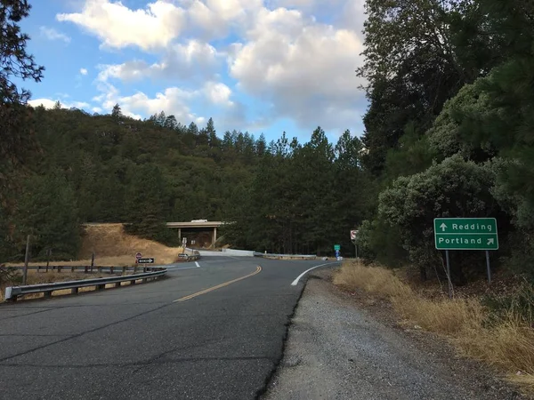 Rural onramp for Interstate 5 in California with a sign pointing towards Redding and Portland
