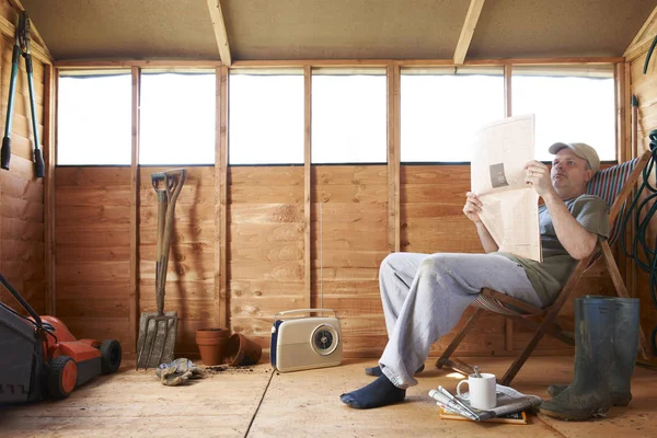 Man Checking Share Prices While Sitting Deckchair His Garden Shed — Stock Photo, Image