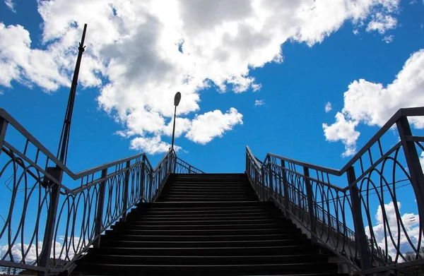 Çok sayıda adımları ile yüksek bir merdiven gökyüzü ve siyahlar yol açar. Kenarlarda gece ışıklar.