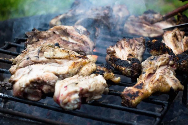 A fragrant, but a little more not ready barbecue from chicken legs and thighs. It is prepared on open fire and smoke in the yard in the village.