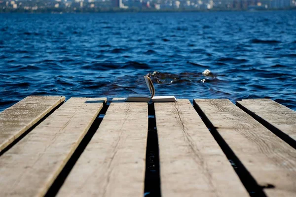 Das Buch Liegt Rand Der Seebrücke Auf Einer Hölzernen Fläche — Stockfoto