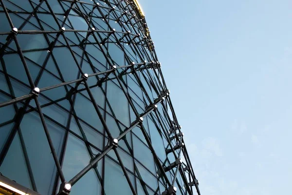 Büyük cam bina windows tarafından parlak ışıklar bir yaz gece ışıklı. Biraz gri ve bulutlu gökyüzü.