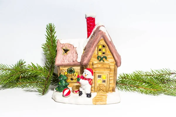 美丽的装饰新年的房子在白色的背景 旁边的一个房子是雪人 房子周围是冷杉分枝 美妙的圣诞气氛 — 图库照片