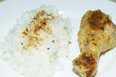 Fırında tavuk baget üzerinde beyaz bir tabak taze pişmiş beyaz pirinç bir kısmı ile yalan. Çok lezzetli yemekler.