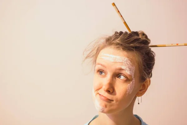 Kirli yüzü un ve beyaz zemin üzerine saçında çubuklar ile kız. Kız yüz şaşkın bakışla.