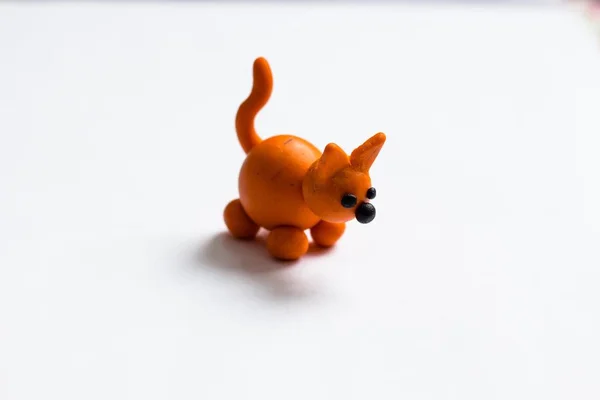 Hafif bir arka planda turuncu renk küçük bir köpek plastikin yapılır. O çok güzel ve dost canlısı bir evcil hayvan.