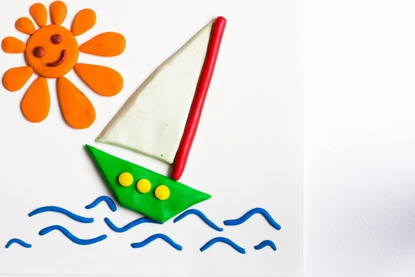 Yeşil gemi ile güçlü dalgalar üzerinde bir beyaz yelken. Deniz ve gemi bir parlak ve gülümseyen güneş parlar.