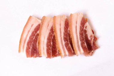 Birkaç taze ve sulu pastırma dilimleri beyaz nötr arka plan üzerinde yalan. Pastırma birçok yemek için yazılı olarak kullanıma hazırdır.