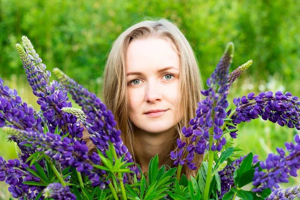 Lupins güzel çiçekler arasında güzel ve genç kız. O mor tonçiçekleri bir demet arasında olmanın an sahiptir.