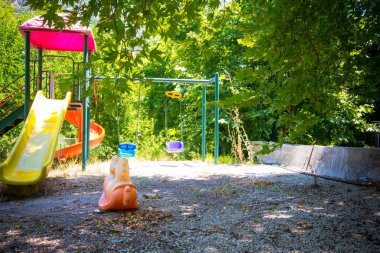 Oyun alanı güneşin parlak ışınları ile aydınlatılır. Oyun alanı uzun zamandır terk edilmiş ve çocuklar artık oyun oynamadı..